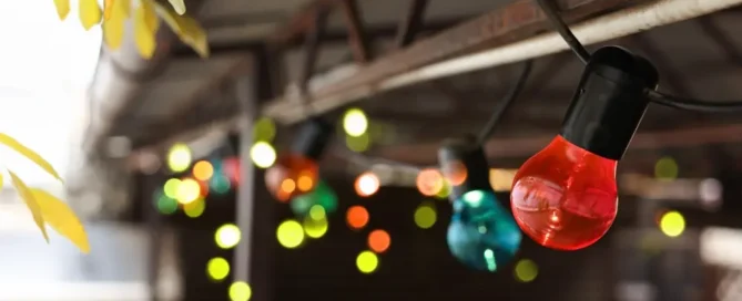 Christmas celebration. Canopy decorated with colorful light bulbs outdoors, closeup.